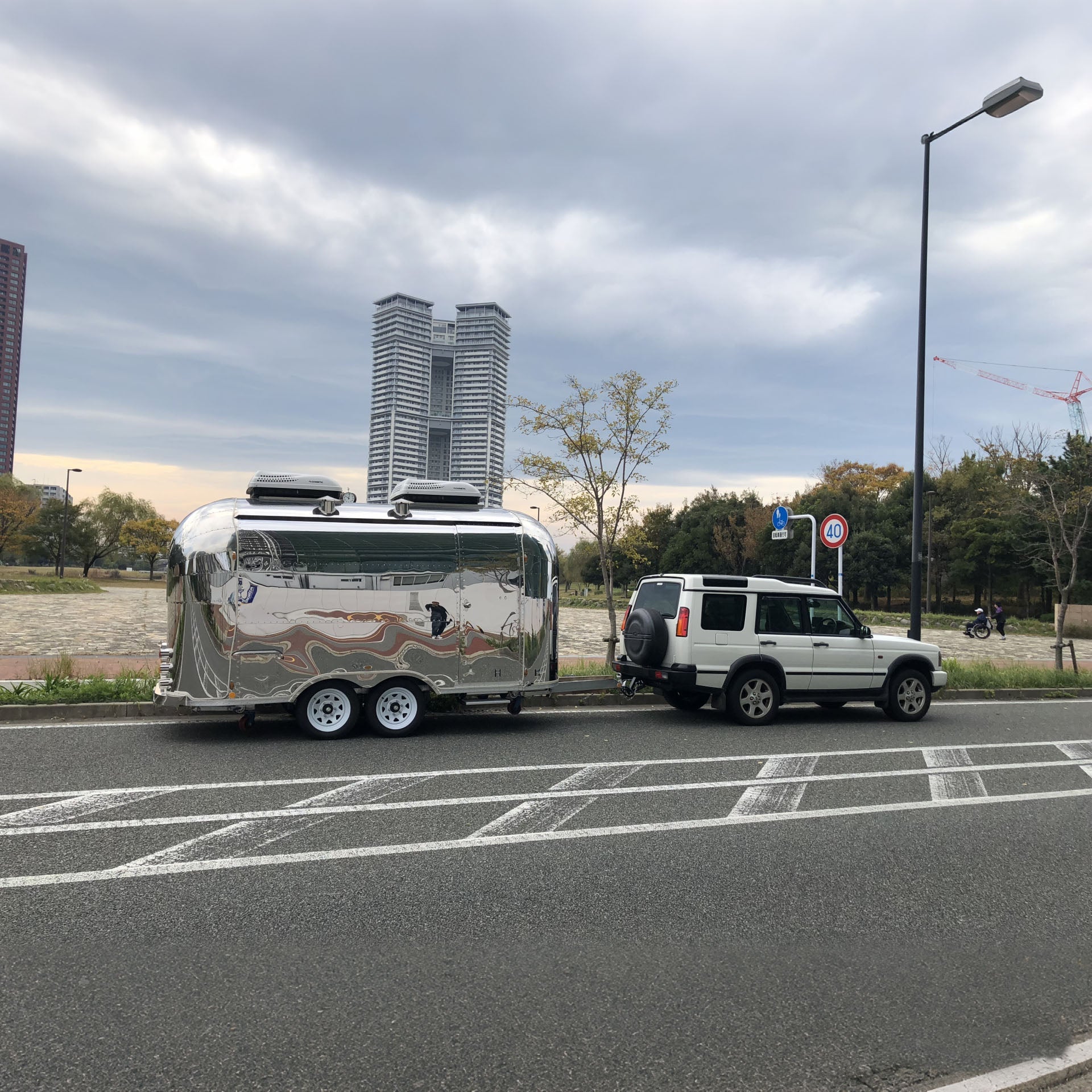Hanyi Food Trailers parked beside a vehicle on an urban street with modern buildings in the background.